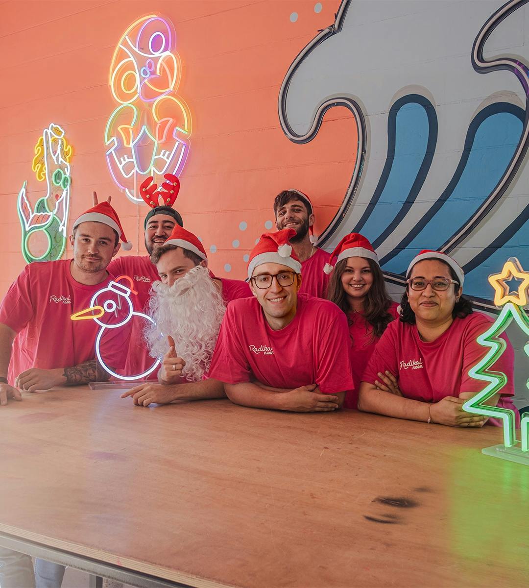 smiling team at Radikal Neon in Christmas outfits